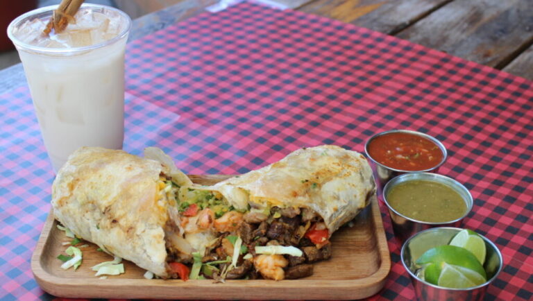 Steak and shrimp burrito served with salsa at Los Tacos Locos